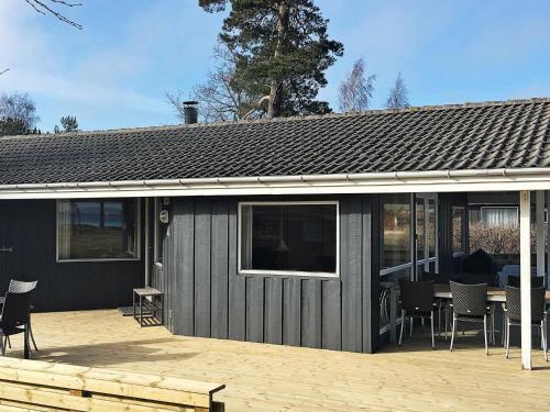 Snogebækにある8 person holiday home in Nexのパティオ(テーブル、椅子付)が備わる家です。