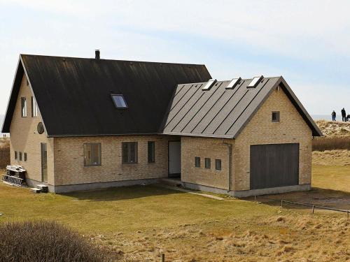 una gran casa de ladrillo con techo negro en 6 person holiday home in Bl vand, en Blåvand