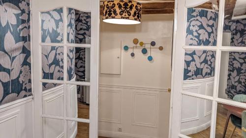 a hallway with a white door and blue and white wallpaper at Opera Louvre Holiday Apartment in Paris