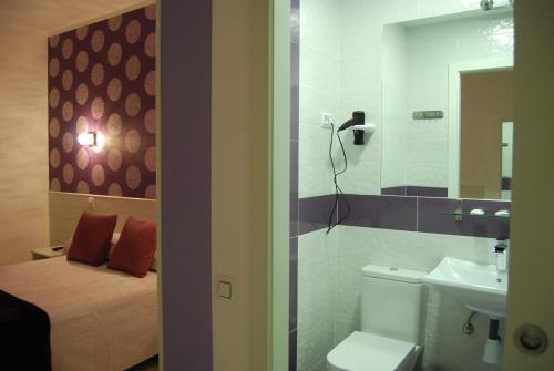 y baño con cama, aseo y lavamanos. en Hostal PETITE MAMAN, en Madrid