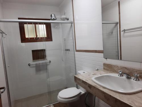 a bathroom with a sink and a toilet and a shower at Chalés Lauterbrunnen in Monte Verde