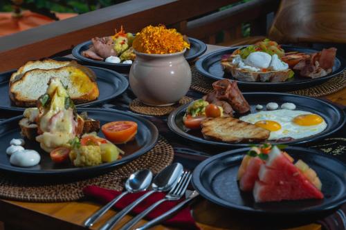 a table with plates of breakfast food on it at GK Bali Resort in Tegalalang