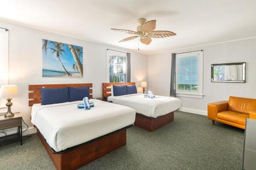 Habitación de hotel con 2 camas y sofá en An Island Oasis en Cayo Hueso