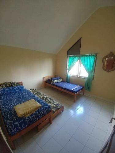 a bedroom with two beds and a window at Villa Segar Alam Puncak in Cinengangirang