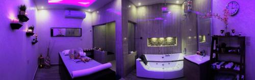 a purple bathroom with a tub and a sink at Aros Al Faisaliah Furnished Units in Dammam