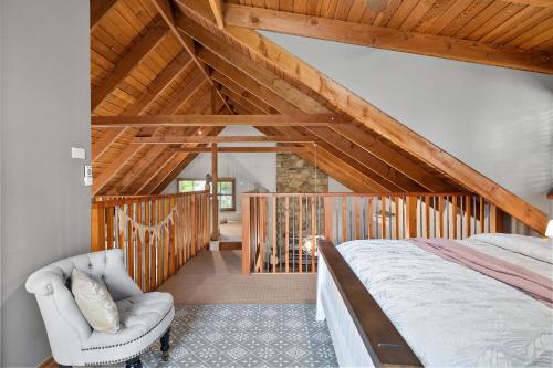 a bedroom with a bed and a chair at Stonehenge Retreat in Ballarat