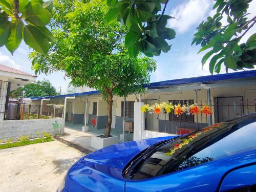 a blue car parked in front of a building at Innskeep in Calingcuan