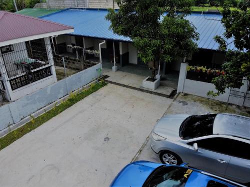 two cars parked in a parking lot in front of a house at Innskeep in Calingcuan