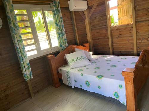 a bedroom with a bed in a wooden cabin at An Ti Kaz La in Sainte-Anne