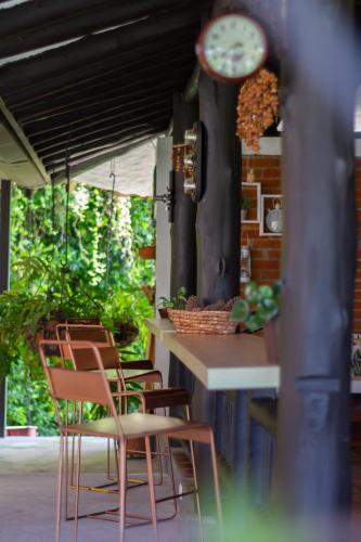 a group of chairs sitting at a table with a clock at Finca Hotel Casa Nostra, villa Mariana in Quimbaya