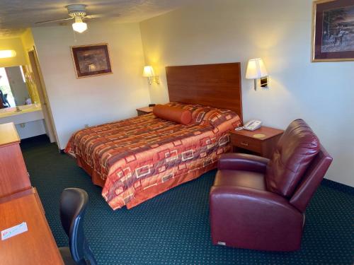 ein Hotelzimmer mit einem Bett und einem Stuhl in der Unterkunft Country Hearth Inn-Union City in Union City