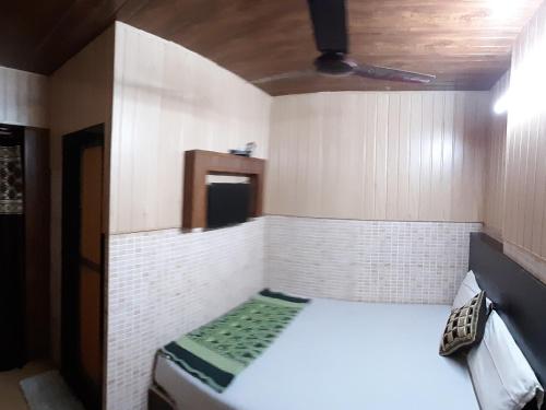 um pequeno quarto com uma cama num quarto em Hotel Regal Plaza em Mumbai