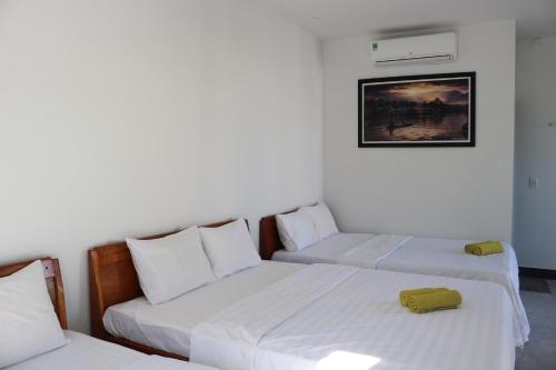 two beds in a room with white walls at Green garden house in Hoi An