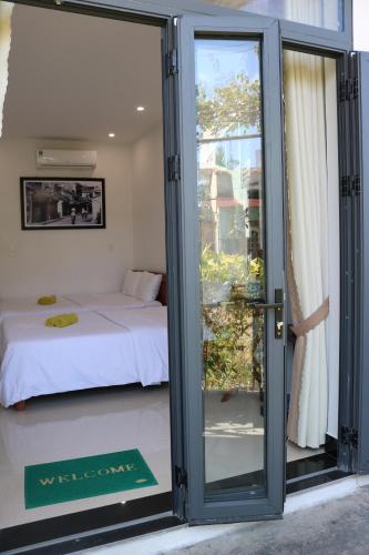 a room with a bed and a sliding glass door at Green garden house in Hoi An
