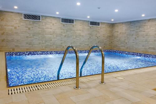 a large indoor swimming pool in a building at The Proud Hotel Al Khobar in Al Khobar