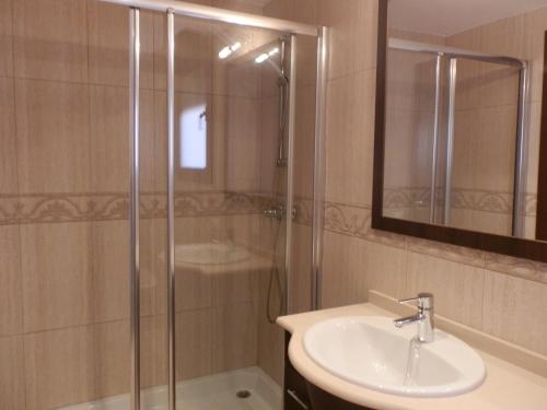 a bathroom with a shower and a sink and a mirror at Casa Bonita in Riumar