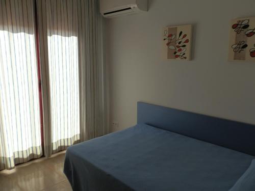 a bedroom with a blue bed and two windows at Casa Bonita in Riumar