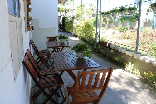 three tables and chairs on a patio with plants at Green garden house in Hoi An