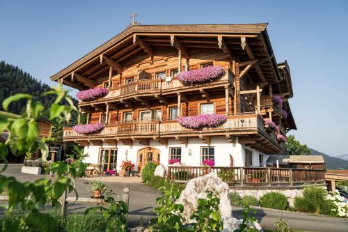 エルマウにあるNaschberghofのバルコニーに花が咲く大きな木造家屋
