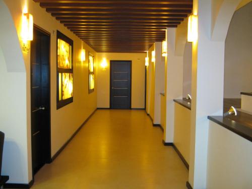 a long hallway with yellow walls and a blue door at Hotel Colonial in Teziutlán