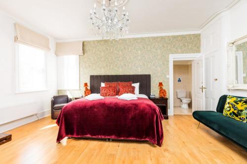 a bedroom with a large bed and a chandelier at Ashbys Accommodation & Spa hire in Portsmouth