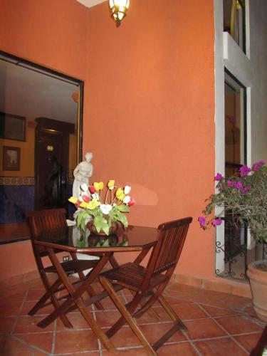 a table with a vase of flowers on it at Hotel Colonial in Teziutlán