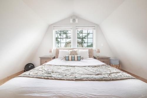 a bedroom with a large white bed with a window at Sea Breeze Cottages in Ocean Shores