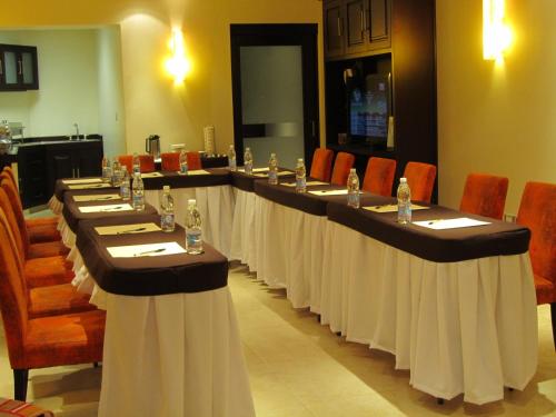 a set of long tables in a room with chairs at Hotel Colonial in Teziutlán