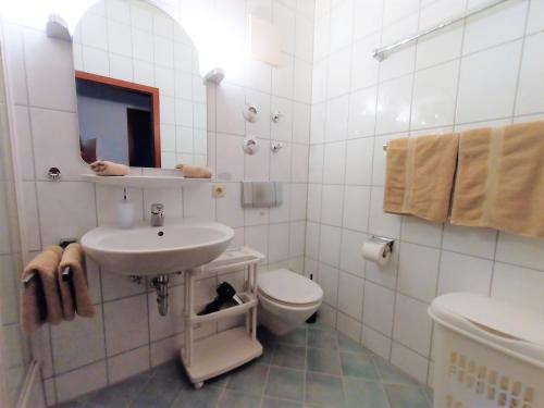 フリードリヒスハーフェンにあるBodenSEE Friedrichshafen City Apartment "WALTRAUD"の洗面台とトイレを備えた白いバスルーム