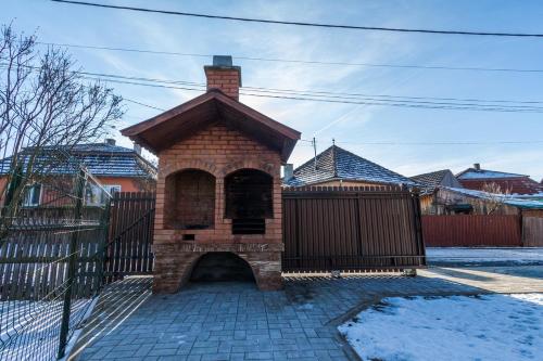 a brick fireplace in front of a fence at Erőss Kulcsosház in Lăzarea