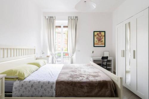 Un dormitorio blanco con una cama grande y una ventana en Appartamento Michelino - in fiera portello, en Milán
