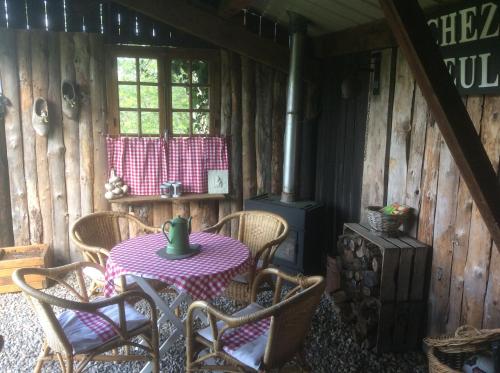 una habitación con mesa y sillas en una cabaña en Chambre d'hotes grange de la bastide en Laveissière