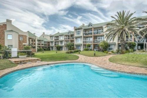 a pool in front of a large apartment building at Blue views at Brookes Hill Suites in Port Elizabeth