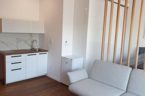 a living room with a chair and a kitchen at Apartmán v srdci Tatier in Dolná Lehota