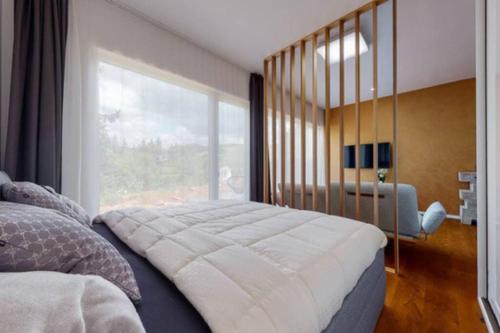 a bedroom with a large bed with a large window at Apartmán v srdci Tatier in Dolná Lehota