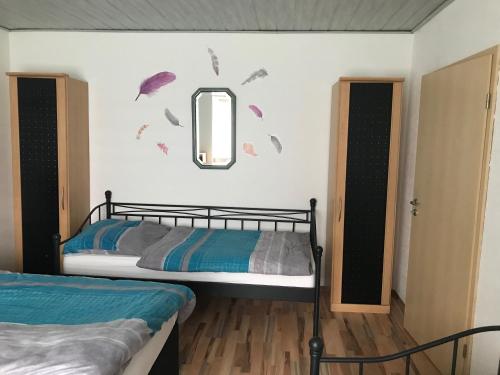 1 Schlafzimmer mit 2 Betten und einem Wandspiegel in der Unterkunft Ferienwohnung in Neunkirchen