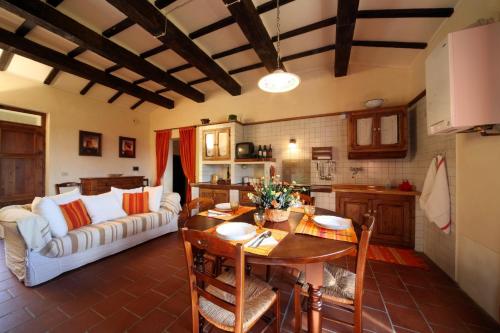 a kitchen and a living room with a table and a couch at Agriturismo Caiburroni in Pietralunga