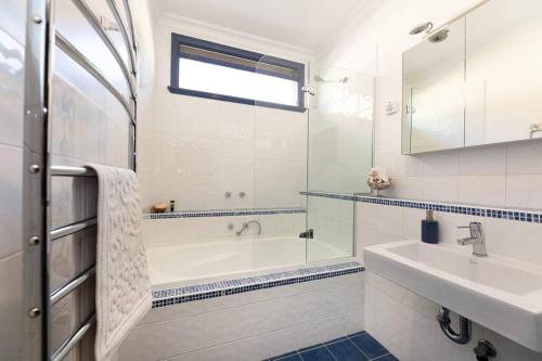 uma casa de banho branca com uma banheira e um lavatório em Cullalo ArtHouse em Albury