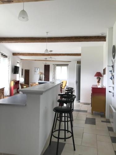 - une cuisine avec un comptoir et des tabourets dans une pièce dans l'établissement La grange du Logis du Plessis, à Chaniers