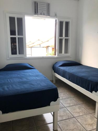 2 camas en una habitación con ventana en Condominio Geriba Buzios , apartamento 205, en Búzios