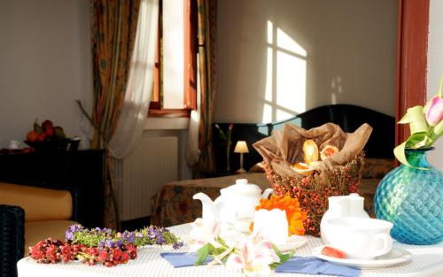 une table avec des vases et des fleurs en haut dans l'établissement La Locanda Azzurra, à Sanremo