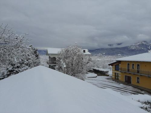 a snow covered roof of a house with mountains in the background at Agriturismo Fior Di Campo in Dronero