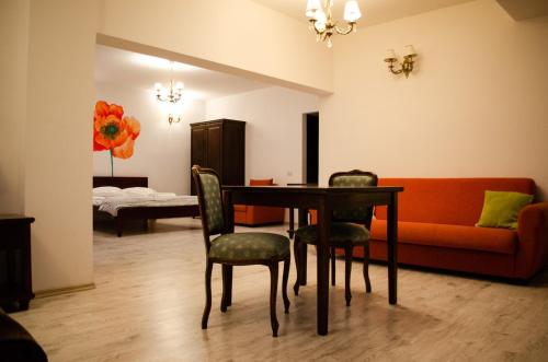 a living room with a table and chairs and a couch at Pensiunea Almas in Piatra Neamţ