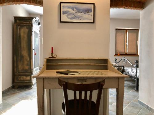 a kitchen with a wooden table and a chair at La Bonauda in Valperga