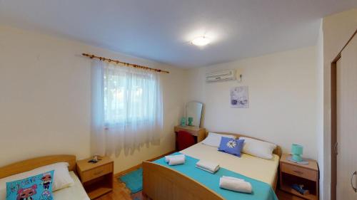 ein kleines Schlafzimmer mit einem Bett und einem Fenster in der Unterkunft Casa Del Sol Bed&Breakfast in Sukošan