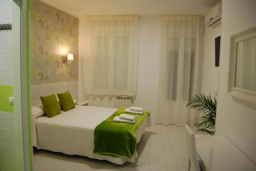 una camera da letto con un letto e asciugamani verdi di Hostal PETITE MAMAN a Madrid