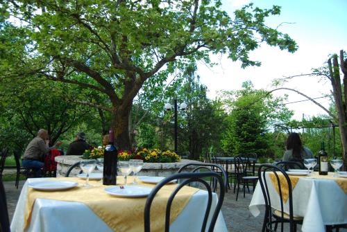 a group of people sitting at tables in a garden at Hotel Faraggi in Kleidonia