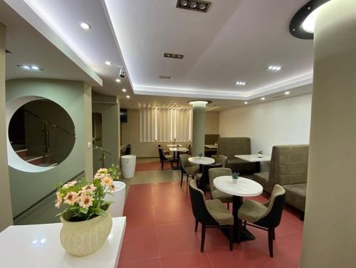 a waiting room with tables and chairs and a couch at Podrinjski san in Loznica