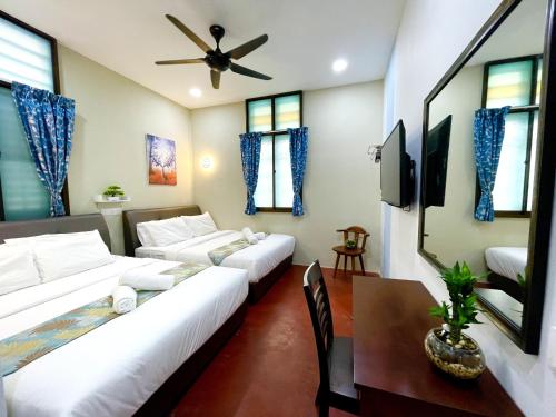 a hotel room with two beds and a dining table at Gurney Treasure - The Vintage Villa by Little Cabin in George Town