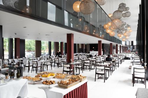 ein Restaurant mit Tischen und Stühlen mit Essen darauf in der Unterkunft Axis Viana Business & SPA Hotel in Viana do Castelo